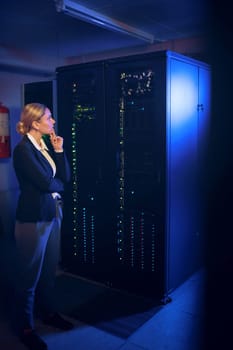 This is complex, let me think about it some more. a young woman looking thoughtful while working in a server room