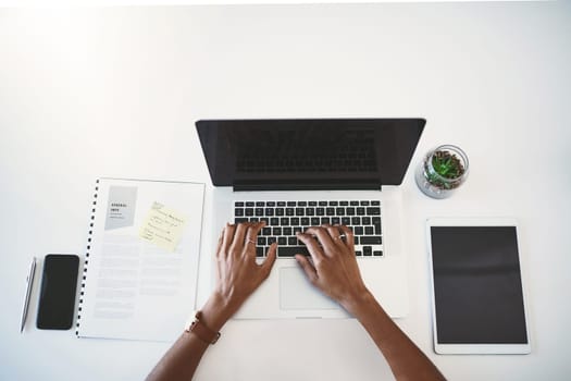 In go getter mode. Cropped high angle shot of a businesswoman using a laptop at her desk in a modern office