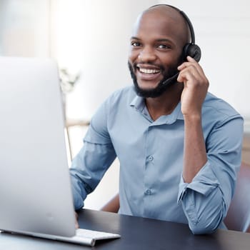 Black man, callcenter with phone call and computer, communication with headset and contact us in office. Male consultant in portrait, customer service and tech support with help desk worker and smile.