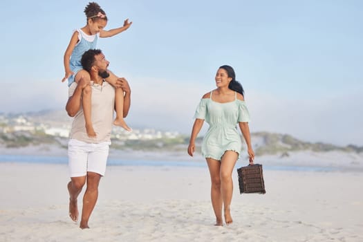 Picnic, parents or kid walking on beach to relax as a happy family on fun summer holiday vacation together. Lovely dad, mother or excited young girl bonding, smiling or holding basket at seashore.