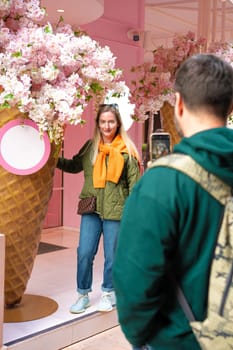 Man taking photo of a woman near flower decoration in Istanbul on mobile phone