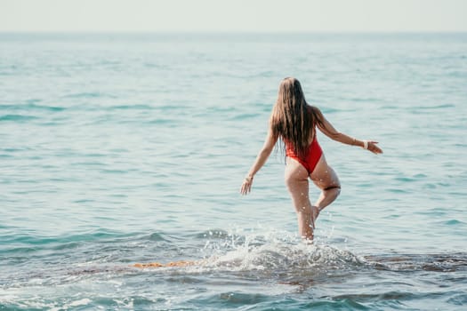 Woman sea yoga. Back view of free calm happy satisfied woman with long hair standing on top rock with yoga position against of sky by the sea. Healthy lifestyle outdoors in nature, fitness concept.