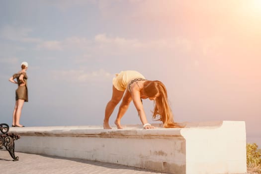 Woman park yoga. Side view of free calm bliss satisfied woman with long hair standing in morning park with yoga position against of sky by the sea. Healthy lifestyle outdoors in park, fitness concept