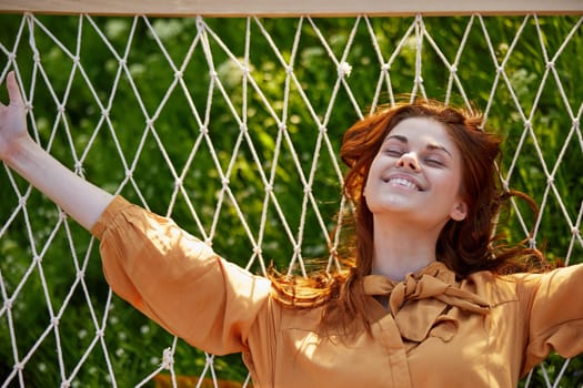 a close horizontal photo of a beautiful woman lying in a hammock with her eyes closed enjoying a rest. High quality photo