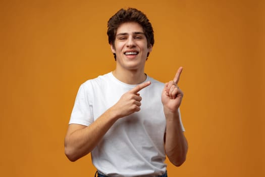 Young handsome man over blue background pointing to the side copy space