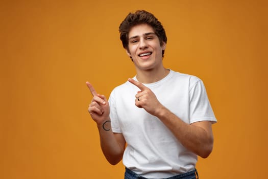 Young handsome man over blue background pointing to the side copy space