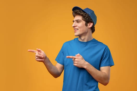 Young handsome man over blue background pointing to the side copy space