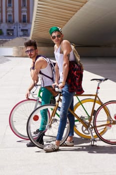 Bicycle, portrait and friends or men in city streetwear for college, university or outdoor travel in summer. Cool youth or people with gen z fashion, sunglasses and bike for urban transport at campus.