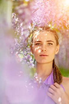 Woman wisteria lilac dress. Thoughtful happy mature woman in purple dress surrounded by chinese wisteria.