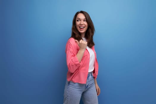 long-haired brunette young adult in a shirt with cheerful emotions on an isolated background.