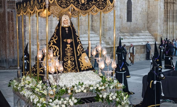 Easter Week in Palencia, Spain. Penitents carrying the image of the Virgin Mary through the streets.