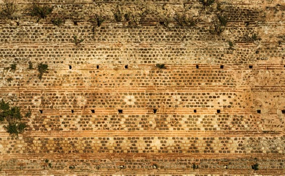 View of the ancient Gallo-Roman wall of Le Mans in France, built with stones in warm tones. Concept for backgrounds and textures.