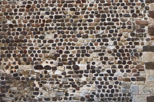 View of old wall built with stones in warm tones. Concept for backgrounds and textures.