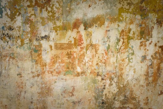 Detail of old wall in warm tones with a lot of texture and remains of paint. Concept for backgrounds and textures.