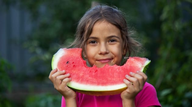 A child eats a watermelon. Selective focus. Nature