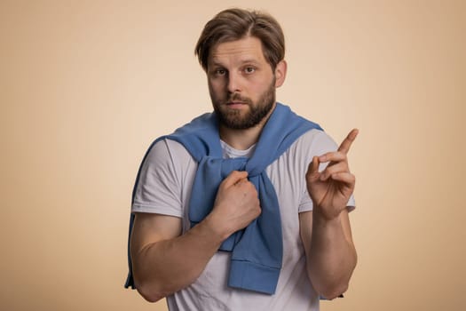 I am dont want it, not me. Confused young caucasian man pointing fingers hisself ask say who why me no thanks i do not need it, rejection, refusal, stop sign. Unhappy guy isolated on beige background