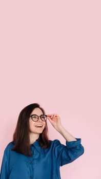 Curious Woman Touching Glasses, Deep in Thought, Searching for Inspiration in Empty Space: Isolated Pink Background Portrait.