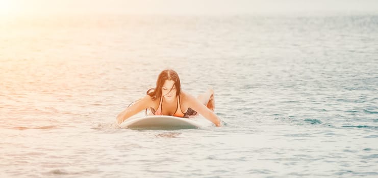 Sea woman sup. Silhouette of happy young woman in pink bikini, surfing on SUP board, confident paddling through water surface. Idyllic sunset. Active lifestyle at sea or river. Slow motion