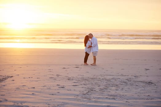 Romance doesnt end at retirement, it gets better. a mature couple kissing on the beach