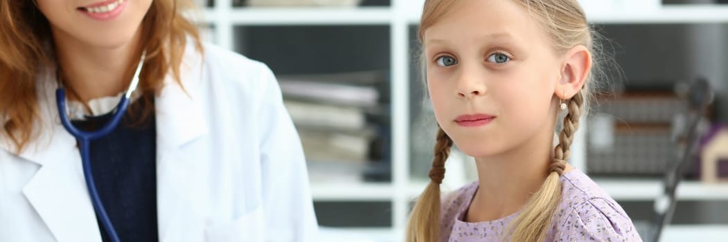 Friendly female pediatrician little girl health in clinic. Medical child insurance concept