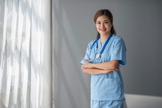 Portrait of female asian doctor standing in her office at clinic...