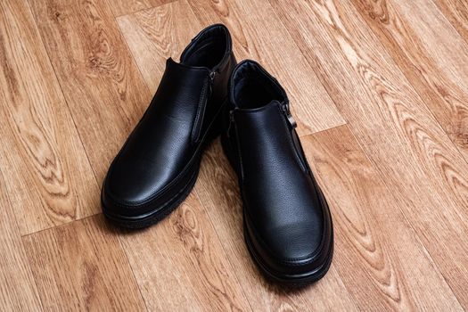 A pair of male shoes on a wooden background close up