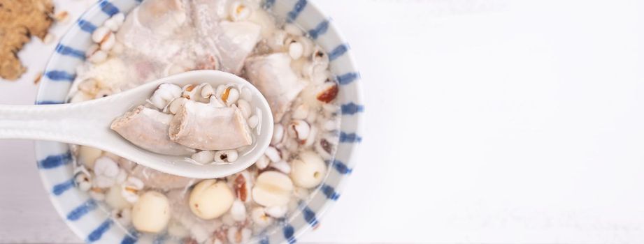 Tasty Four Tonics Herb Flavor Soup, Taiwanese traditional food with herbs, pork intestines on white wooden table, close up, flat lay, top view.