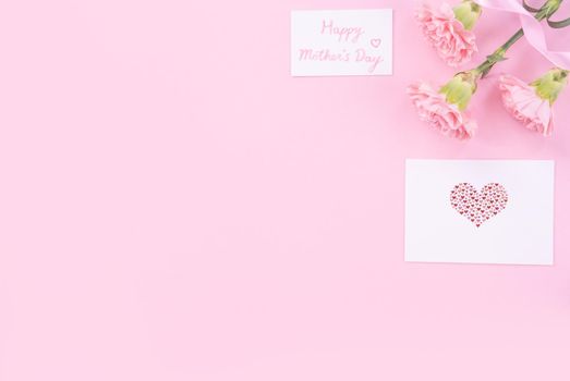 Beautiful, fresh elegant carnation flower bouquet with white greeting thanks gift card isolated on bright pink color background, top view, flat lay concept.