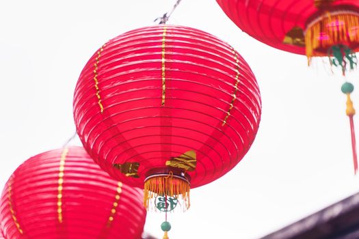 Beautiful round red lantern hanging on old traditional street, concept of Chinese lunar new year festival, close up. The undering word means blessing.