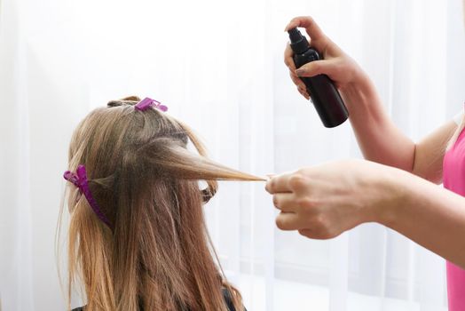 Hairstylist Spraying female Hair in beauty salon