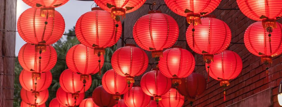 Beautiful round red lantern hanging on old traditional street, concept of Chinese lunar new year festival, close up. The undering word means blessing.