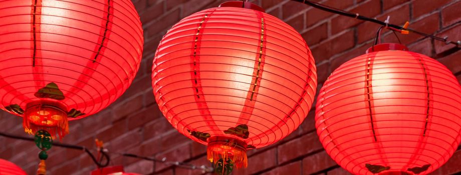 Beautiful round red lantern hanging on old traditional street, concept of Chinese lunar new year festival, close up. The undering word means blessing.