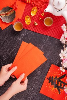 Design concept of Chinese lunar January new year - Woman holding, giving red envelopes (ang pow, hong bao) for lucky money, top view, flat lay, overhead above. The word 'chun' means coming spring.