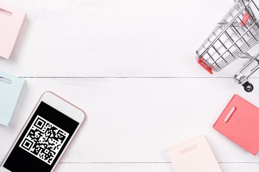 Abstract online shopping, mobile payment with QR code design concept element, colorful cart, paper bag on wooden table background, top view, flat lay