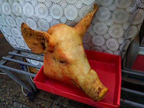 The pig's head is lying on the market counter.