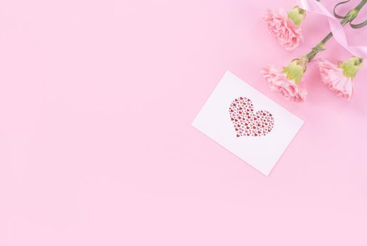 Beautiful, fresh elegant carnation flower bouquet with white greeting thanks gift card isolated on bright pink color background, top view, flat lay concept.