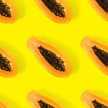 Fresh ripe papaya seamless pattern on yellow background. Tropical abstract background. Top view. Creative design, minimal flat lay concept. Trend tropical fruit food background pattern