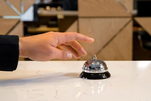 Hand of a man using a retro hotel bell