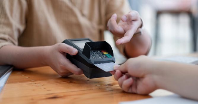 Customer using credit card for purchase to waitress EDC at cashier, Credit card payment concept.