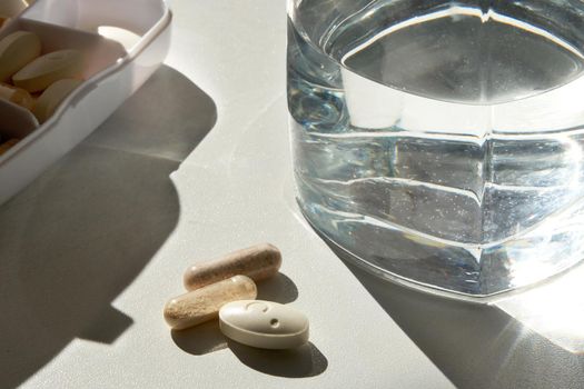 Glass of Water and Pills on white background
