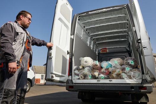 Worker standing near truck full of carpets. Cleaning service concept. High quality photo