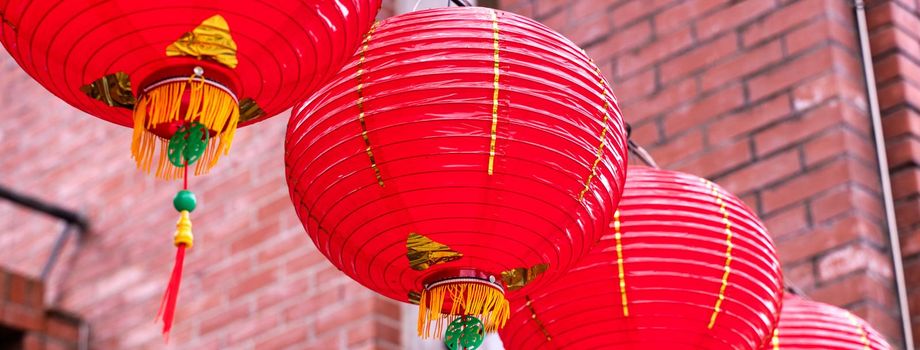 Beautiful round red lantern hanging on old traditional street, concept of Chinese lunar new year festival, close up. The undering word means blessing.