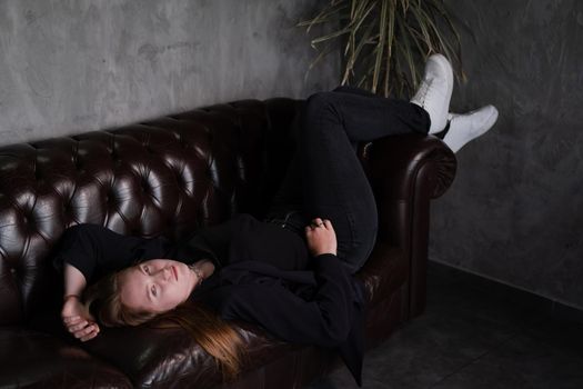 portrait of confident woman in black in dark room. pensive serious people. business woman. feminine. millennial people.