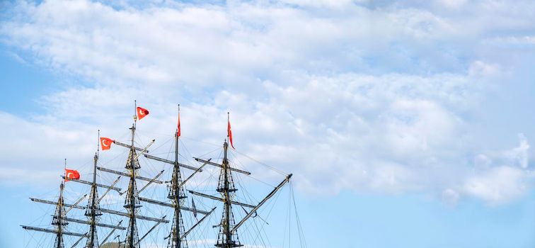 Masts of the ship with turkish flags on the background of the blue sky. The concept of travel and freedom. Copy space