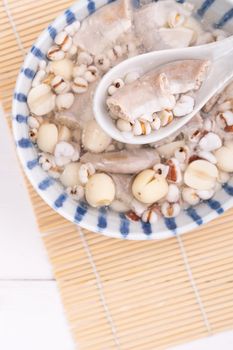 Tasty Four Tonics Herb Flavor Soup, Taiwanese traditional food with herbs, pork intestines on white wooden table, close up, flat lay, top view.