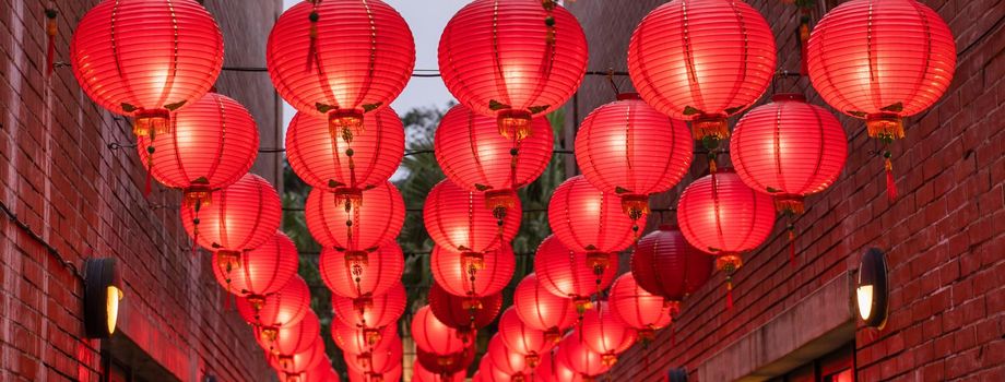 Beautiful round red lantern hanging on old traditional street, concept of Chinese lunar new year festival, close up. The undering word means blessing.