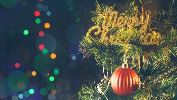 Beautiful Christmas decor concept, bauble hanging on the Christmas tree with sparkling light spot, blurry dark black background, macro detail, close up.