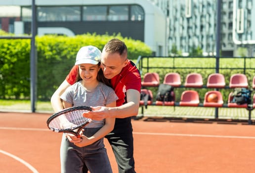Active family playing tennis on court.