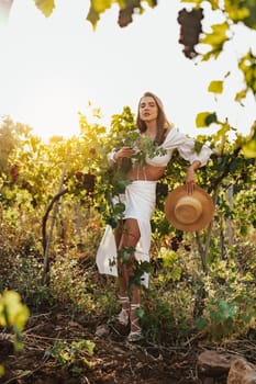 Beautiful young blonde woman walking outdoors in vineyard in summer time
