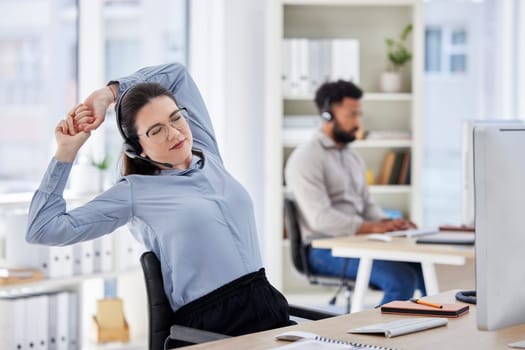 Consultant, lazy woman call center agent with stretch and tired at her desk with a computer of workplace. Online communication or telemarketing, burnout and female person stretching for fatigue.